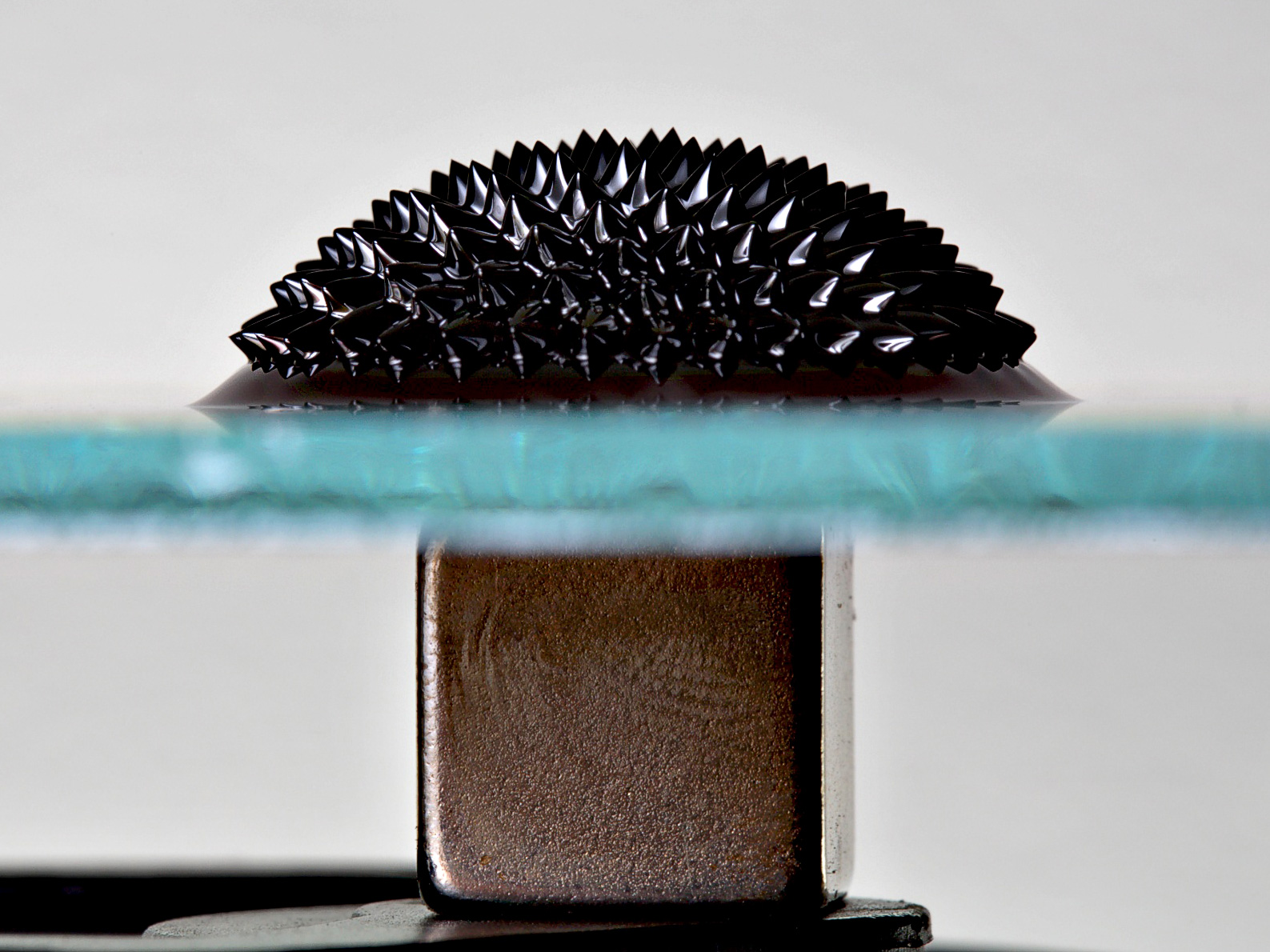 ferrofluid on glass plate under which a strong magnet is placed
